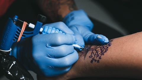 Een tatoeëerder aan het werk